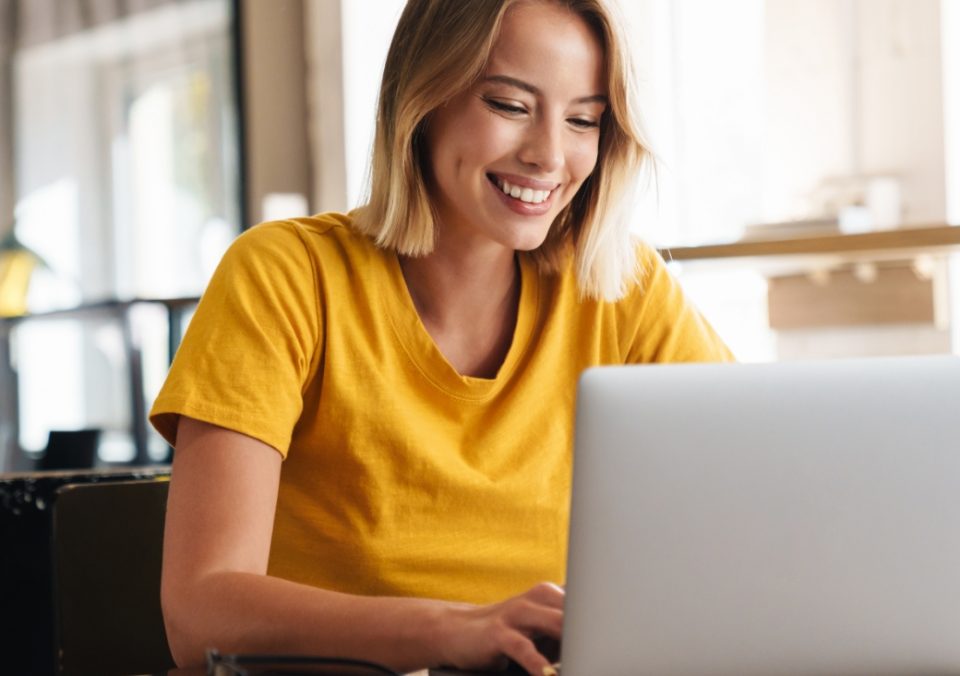 Mentor smiling while messaging with a student on their laptop