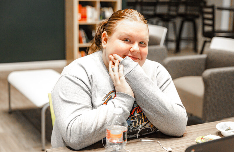 Student sitting at a laptop smiling