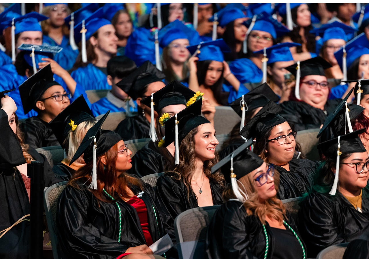 Graduates sitting in an auditorium at their ceremony