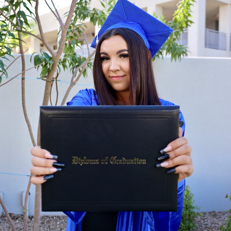 Graduate holding her diploma after graduation