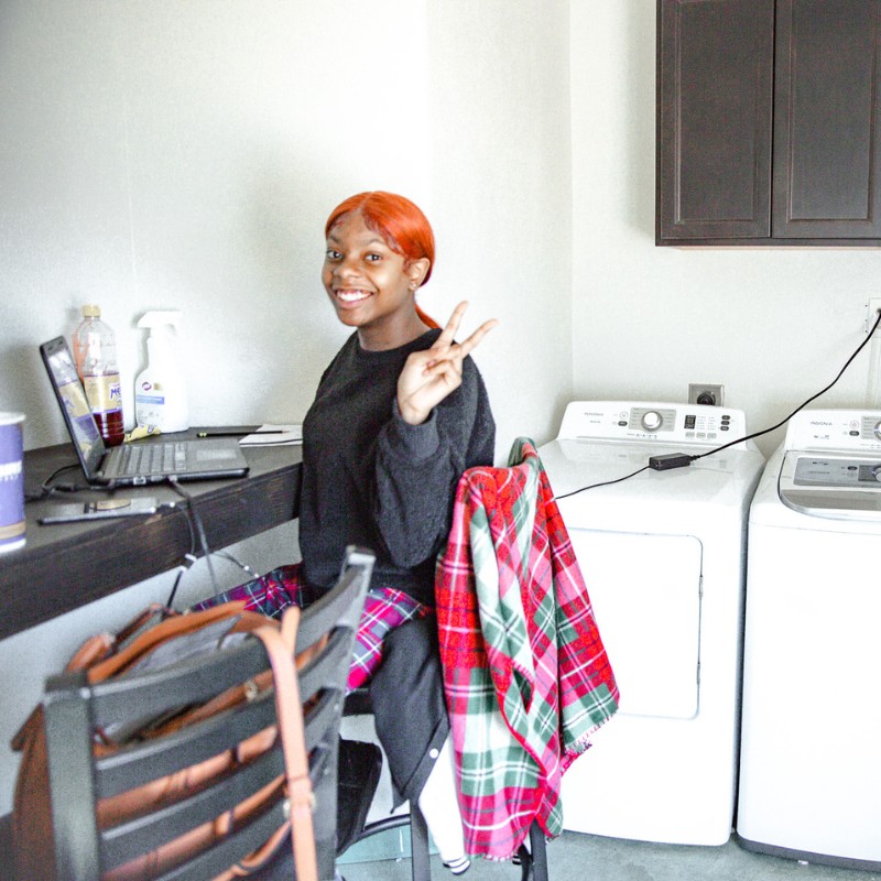 Student completing coursework while doing her laundry at the Phoenix HUB