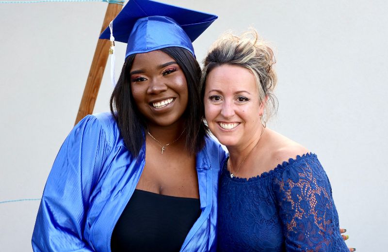 Mentor smiling with a student on their graduation day