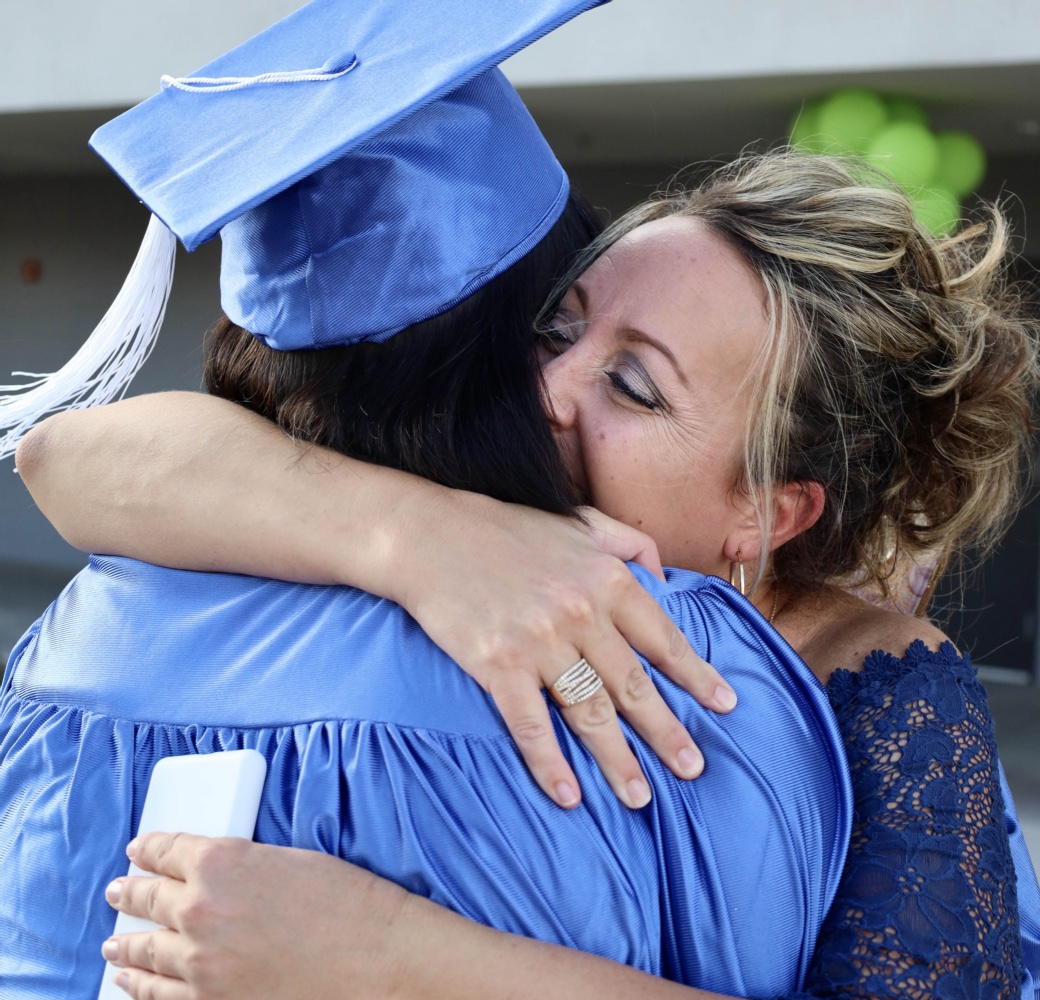 Mentor hugging a student on their graduation day