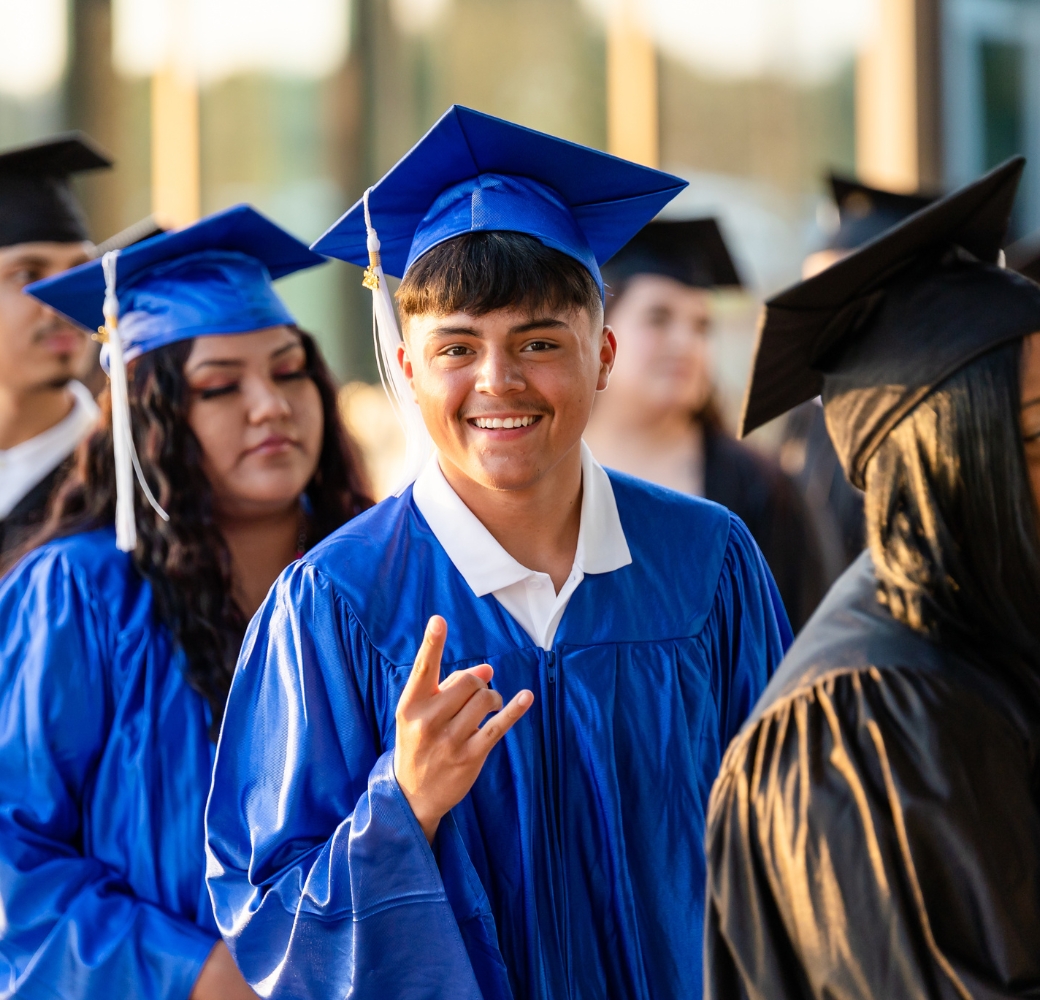 Student smiling, about to walk into his graduation ceremony