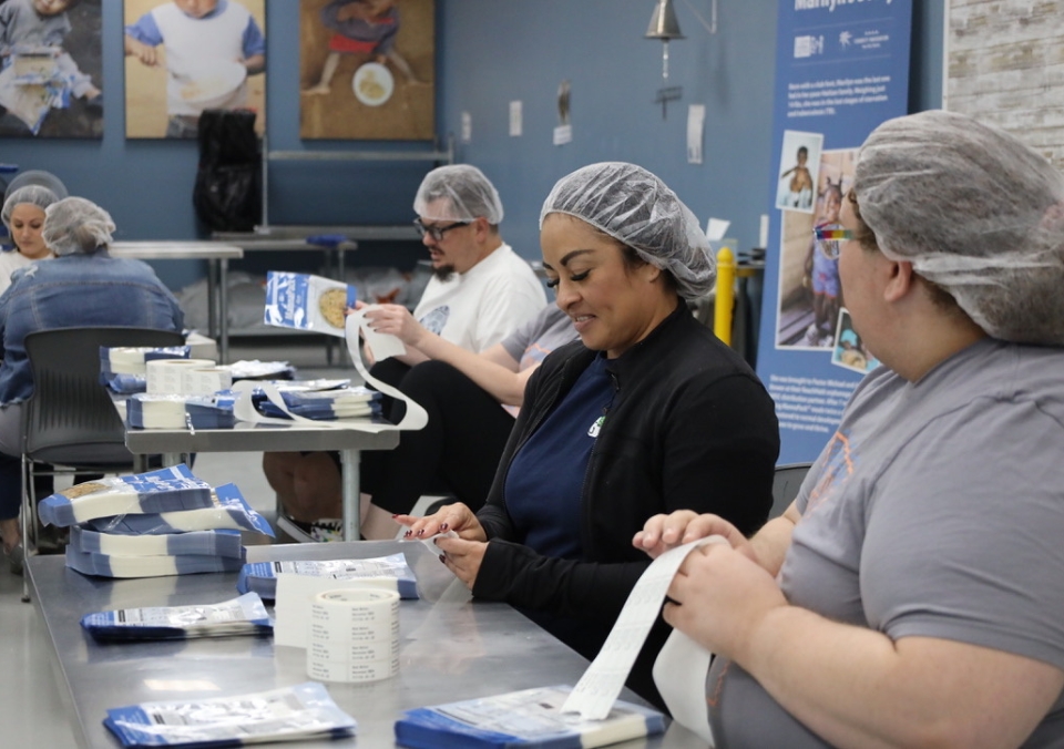 Employees serving at a food packing event