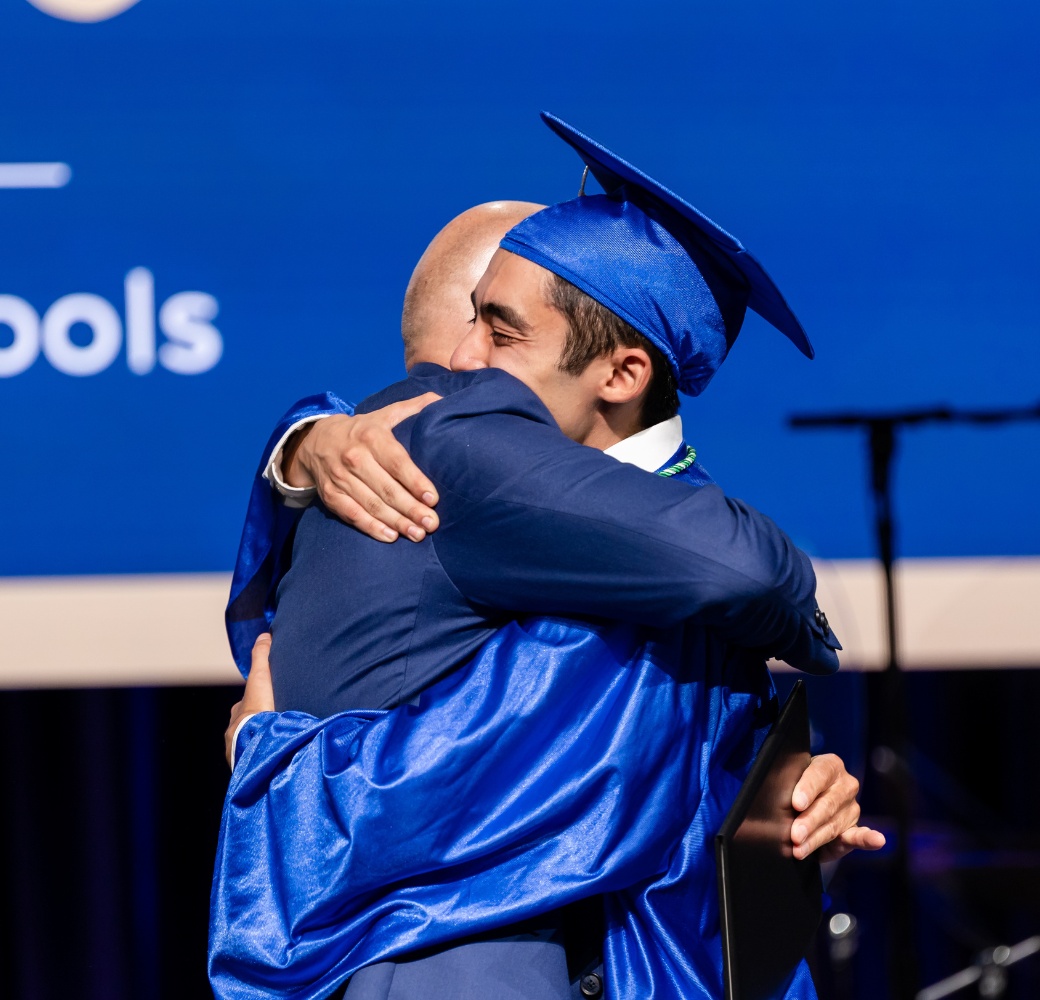 Student hugging Graduation Solutions Founder Jim Lee after receiving his diploma