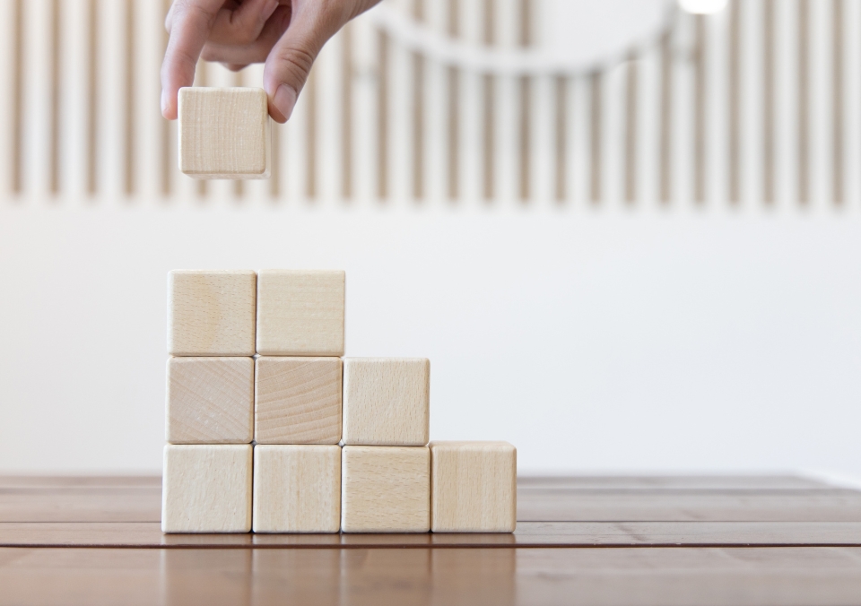 A hand stacking cubes on a table