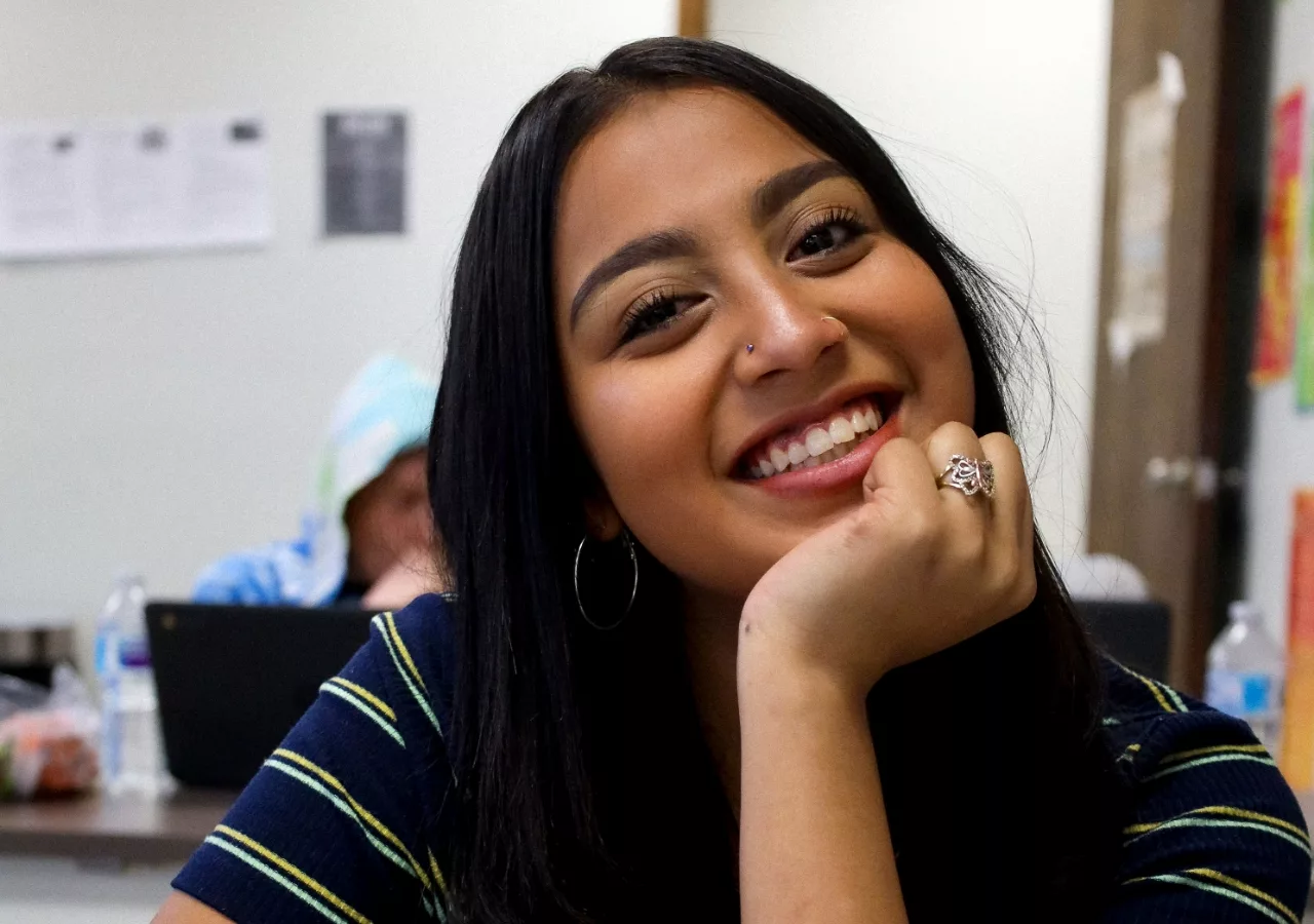 Student smiling while working on their class