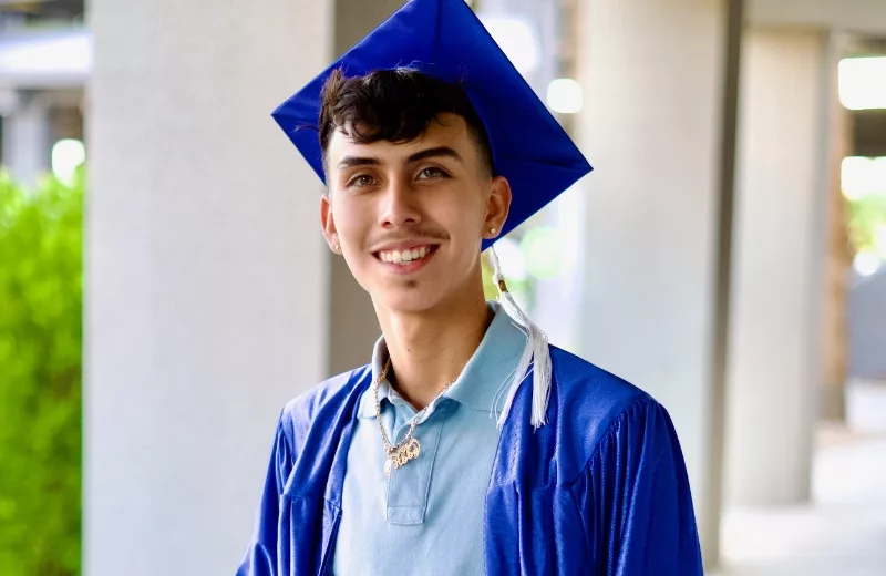 Student smiling outside the graduation auditorium