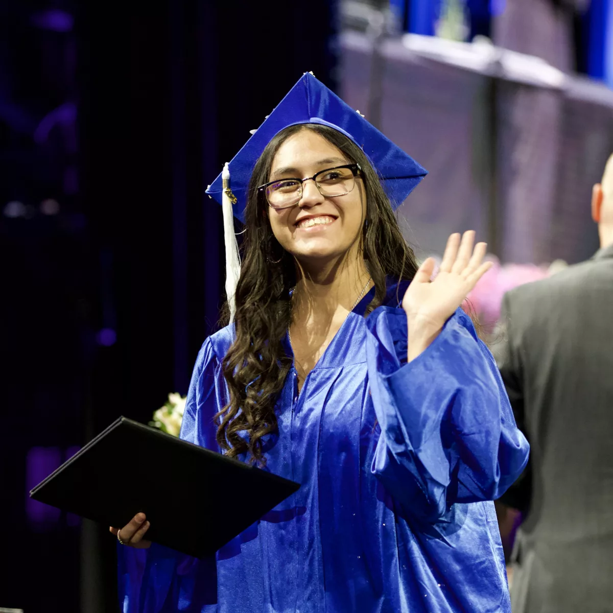 Graduate walking across the stage with their diploma