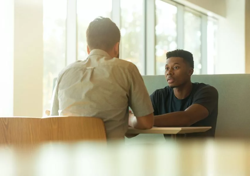 Student sitting down with an advisor, receiving guidance