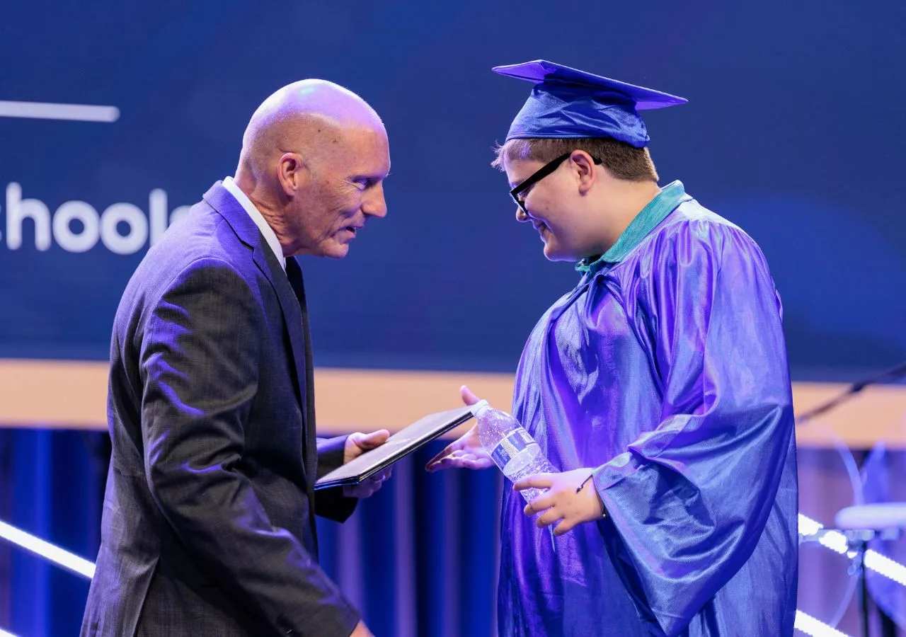 A graduate receiving their diploma on stage