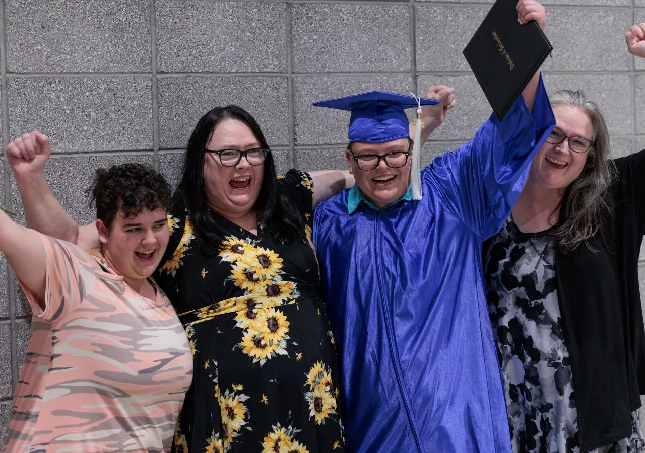 A student surround by those who have supported them all the way to graduation