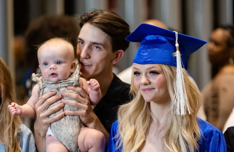 Young family smiling after a Grad Solutions graduation ceremony