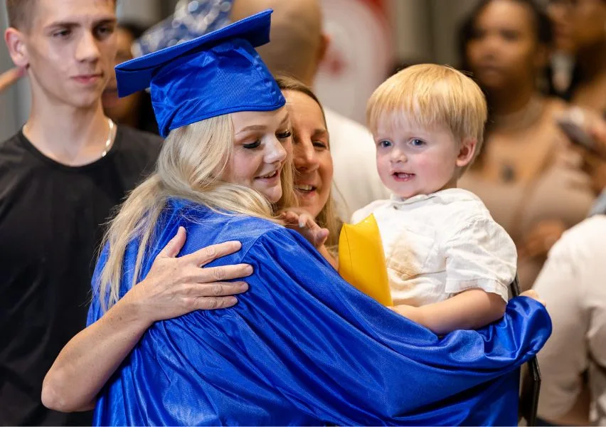 Graduate hugging her son after graduation