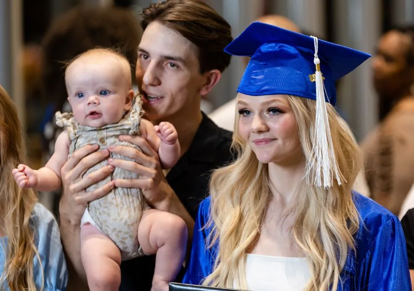 Graduate poses for photo after graduation with her daughter