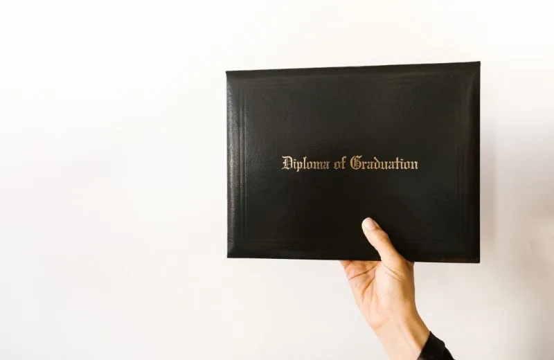 Hand holding a diploma cover
