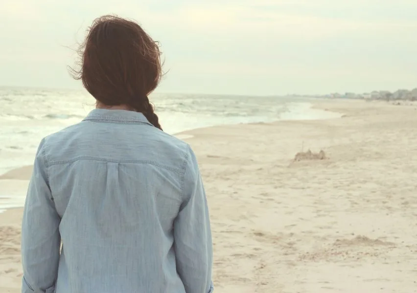 Woman looking out over an empty shote