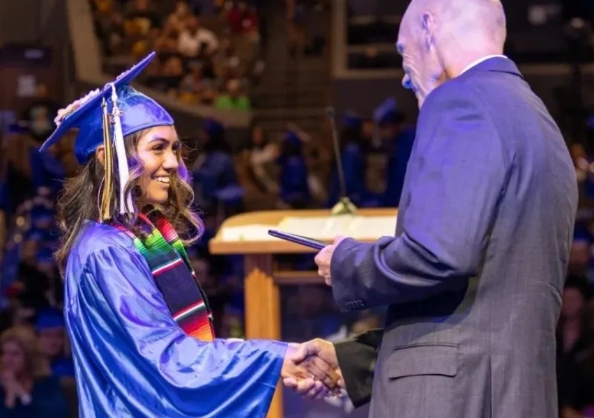 Student receiving their diploma on stage at graduation