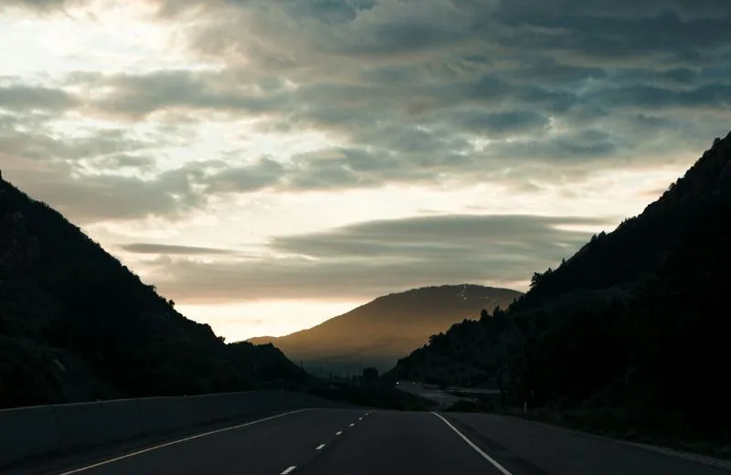 Looking down a desolate highway at sunset