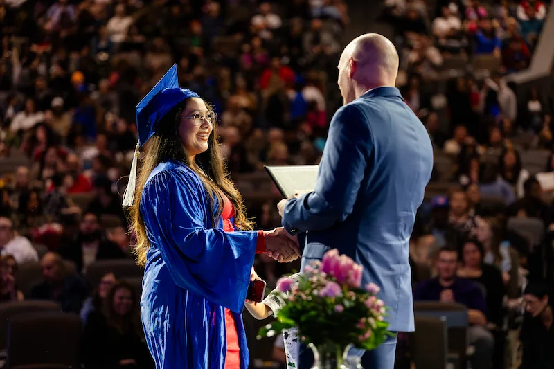 Graduate student accepting high school diploma