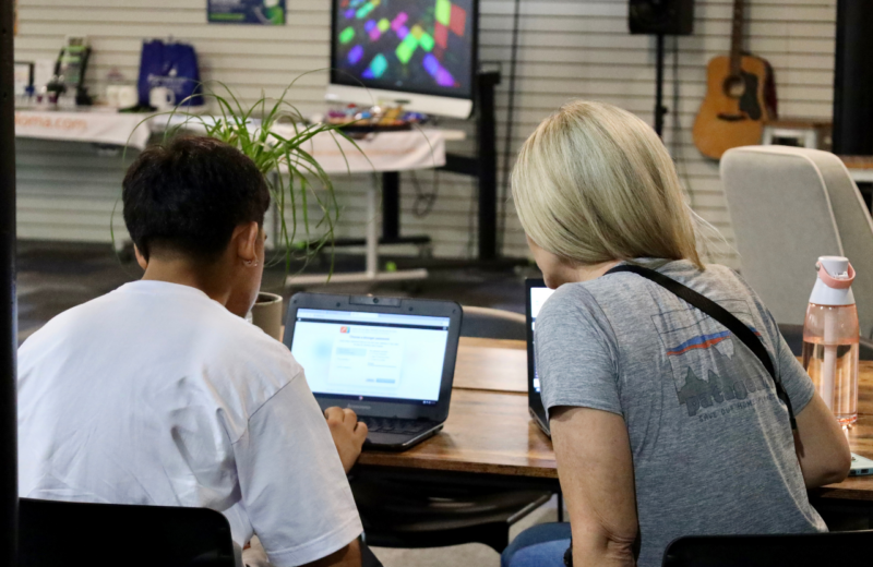 Student mentoring in a classroom with computer