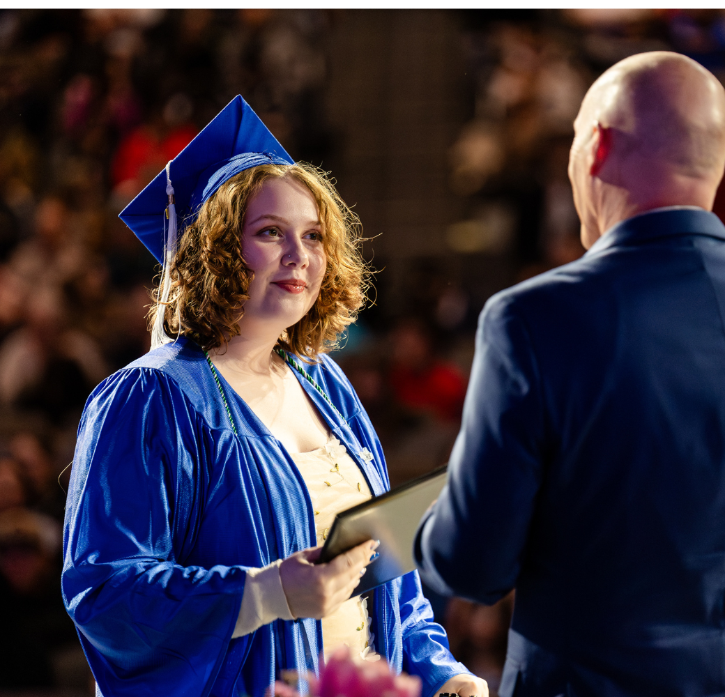 Student receiving her diploma from mentor