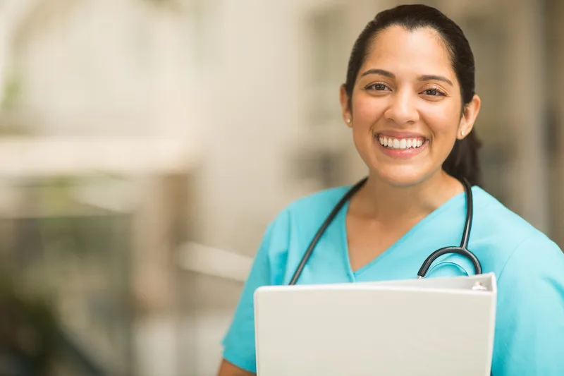 Medical assistant smiling in doctor's office.