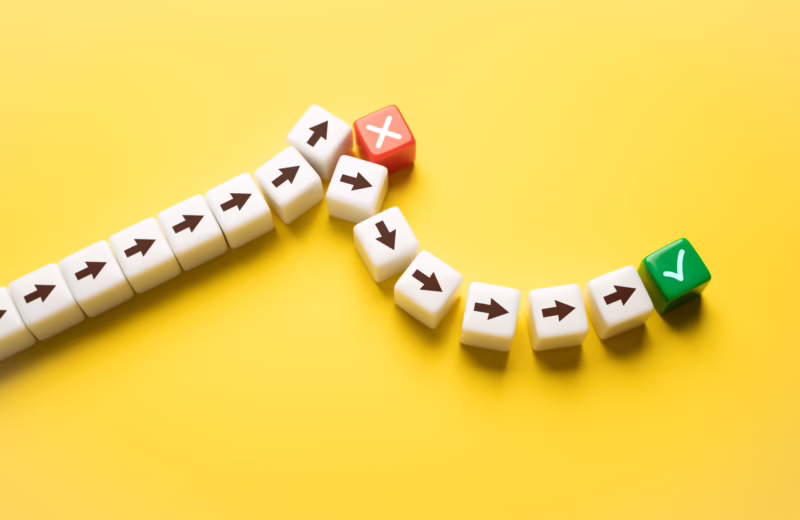 White arrow blocks split into two paths on a yellow background, with one leading to a red X and the other to a green check mark, symbolizing choosing online high school over a GED.